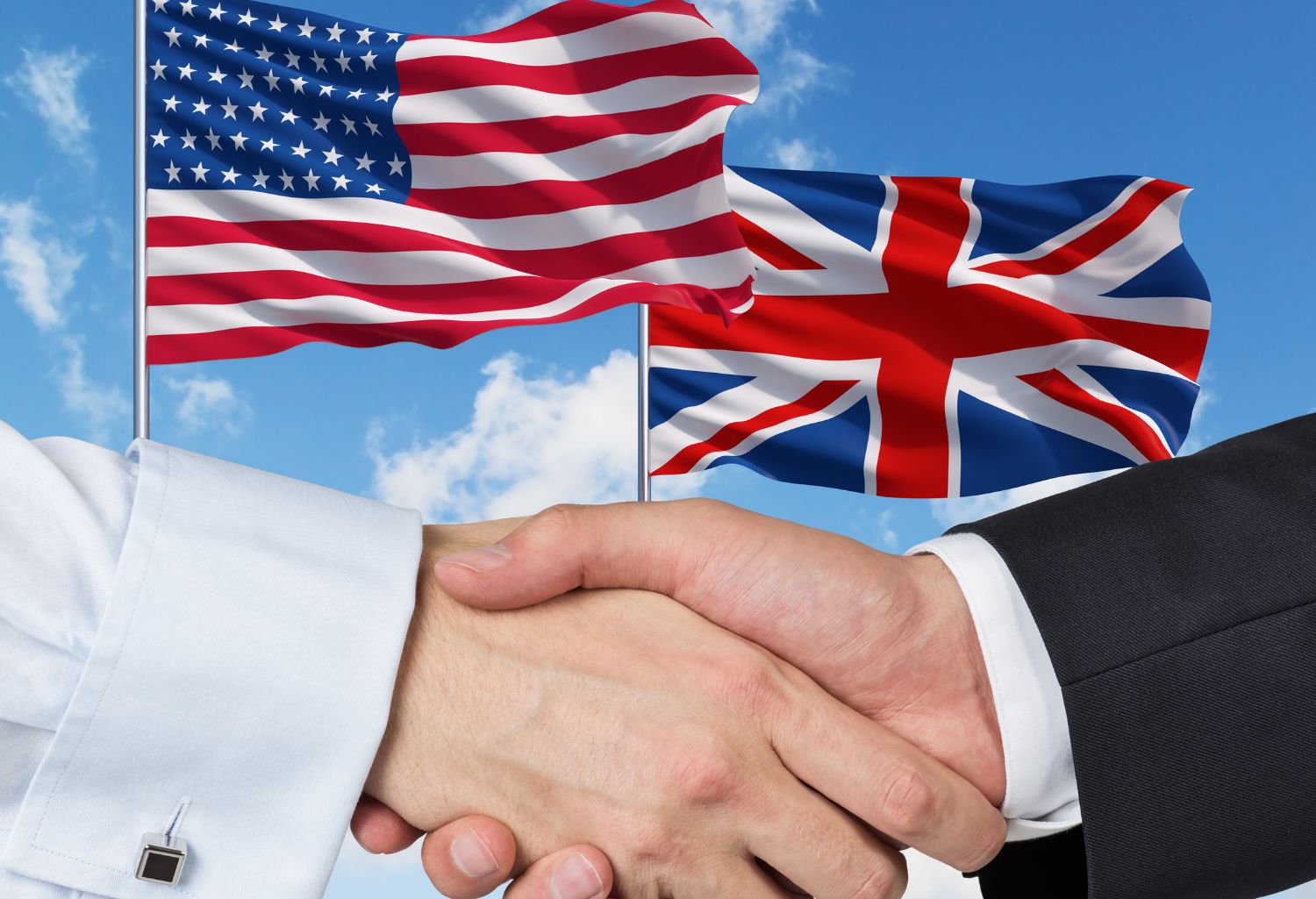 International Wholesale Trade: UK and US flags with a handshake on a blue sky background.